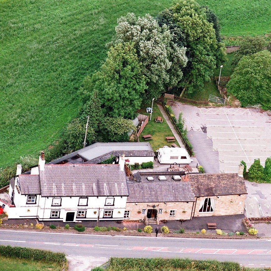 The White Crow from the air: the whitewashed pub on Chorley Road, with the garden and car park behind