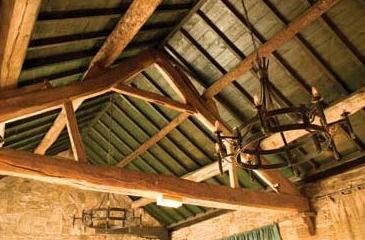 Old timber beams and an iron chandelier in the roof of the pub