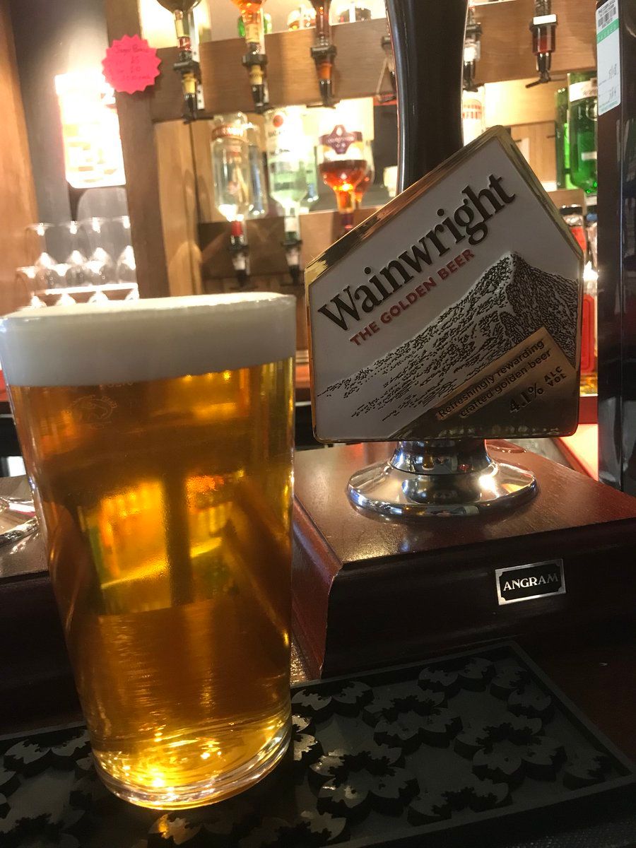 A pint of Wainwright on the bar, next to the pump